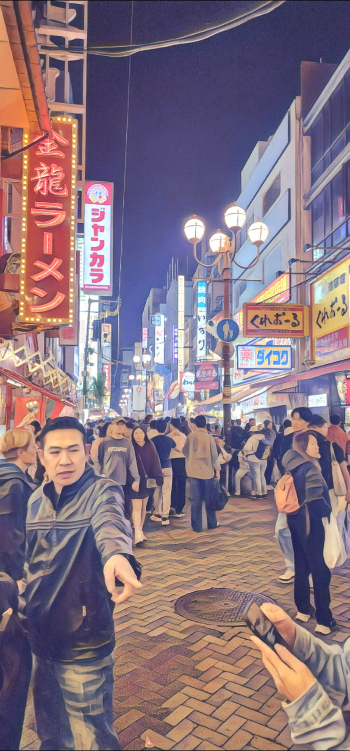 Busy Japanese night street with tall ramen sign at left; people crowding the lane, one person pointing in the foreground.”